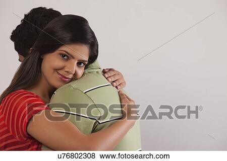 Stock Photo - Portrait of a woman hugging a man. Fotosearch