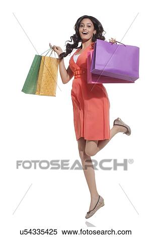 Portrait of a woman jumping with shopping bags View Large Photo Image Stock Photography - Portrait of a woman jumping with shopping bags. Fotosearch