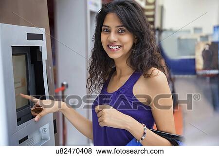 Portrait of a woman next to an ATM machine View Large Photo Image Stock Photo - Portrait of a woman next to an ATM machine . Fotosearch