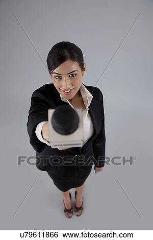 Portrait of a woman reporter holding out microphone against colored background View Large Photo Image Stock Photograph - Portrait of a woman reporter holding out microphone against colored background . Fotosearch
