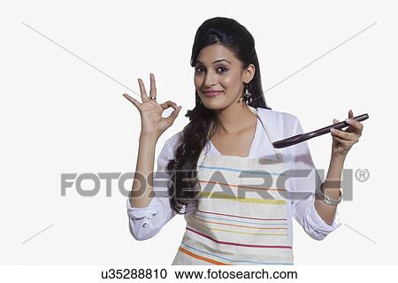 Portrait of a woman with a cooking utensil giving ok sign View Large Photo Image Stock Image - Portrait of a woman with a cooking utensil giving ok sign. Fotosearch