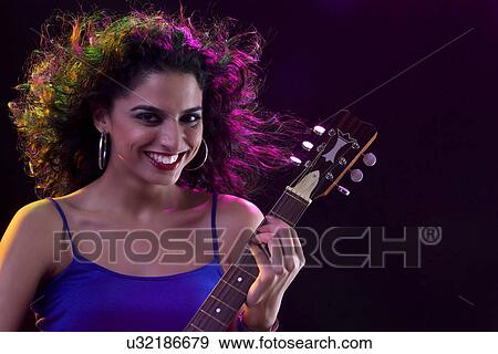 Stock Photo - Portrait of a woman with a guitar . Fotosearch