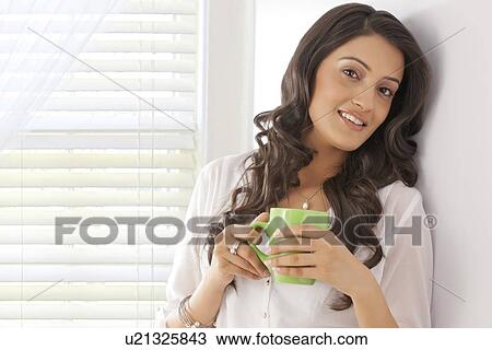 Stock Image - Portrait of a woman with a mug of tea. Fotosearch