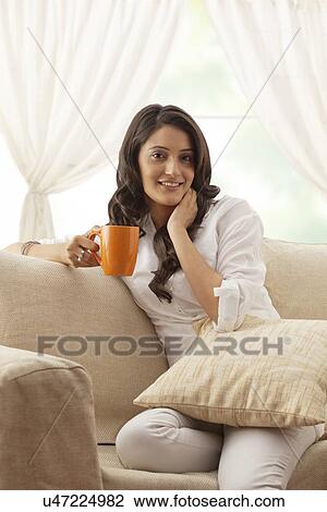Stock Image - Portrait of a woman with a mug of tea. Fotosearch