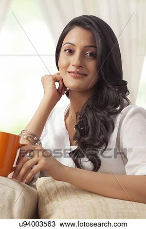 Stock Image - Portrait of a woman with a mug of tea. Fotosearch