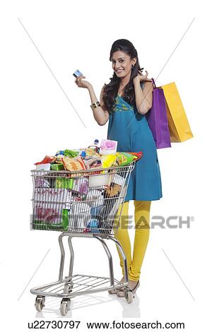 Stock Photo - Portrait of a woman with a shopping cart, shopping bags and credit card. Fotosearch