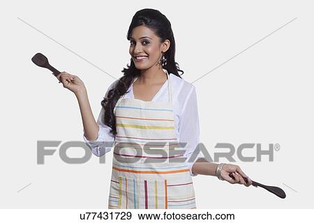 Stock Photo - Portrait of a woman with cooking utensils. Fotosearch