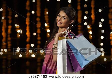 Stock Image - Portrait of a woman with shopping bags. Fotosearch
