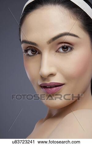 Portrait of a young female smiling over colored background View Large Photo Image Stock Image - Portrait of a young female smiling over colored background . Fotosearch