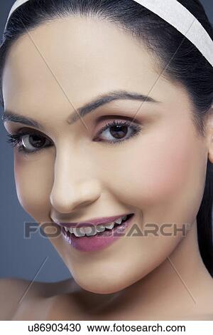 Portrait of a young female smiling over colored background View Large Photo Image Stock Image - Portrait of a young female smiling over colored background . Fotosearch