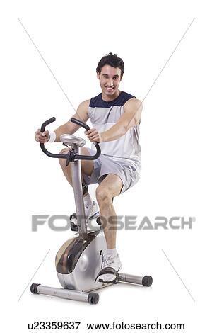 Stock Photo - Portrait of a young fit man on exercise bike over white background . Fotosearch