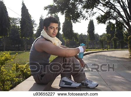 Stock Photo - Portrait of a young man with towel round shoulders resting after sport activities . Fotosearch