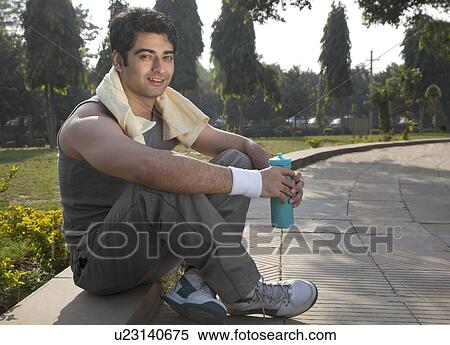 Portrait of a young man with towel round shoulders resting after workout View Large Photo Image Stock Photography - Portrait of a young man with towel round shoulders resting after workout . Fotosearch