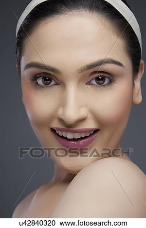 Portrait of a young woman smiling over colored background View Large Photo Image Stock Image - Portrait of a young woman smiling over colored background . Fotosearch