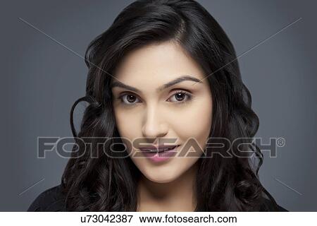 Portrait of a young woman with beautiful hair smiling over colored background View Large Photo Image Stock Photo - Portrait of a young woman with beautiful hair smiling over colored background . Fotosearch