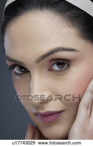 Portrait of an attractive female touching her face over colored background View Large Photo Image Stock Photo - Portrait of an attractive female touching her face over colored background . Fotosearch