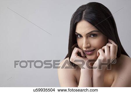 Picture - Portrait of an attractive female with long hair smiling over colored background . Fotosearch