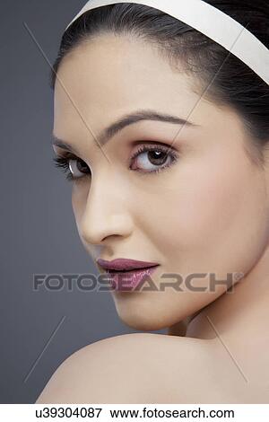 Stock Photo - Portrait of an attractive woman looking over shoulder . Fotosearch