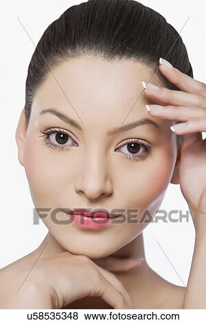 Stock Photo - Portrait of an attractive woman touching her face . Fotosearch