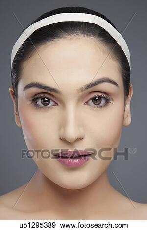 Stock Photo - Portrait of an attractive young female over colored background . Fotosearch