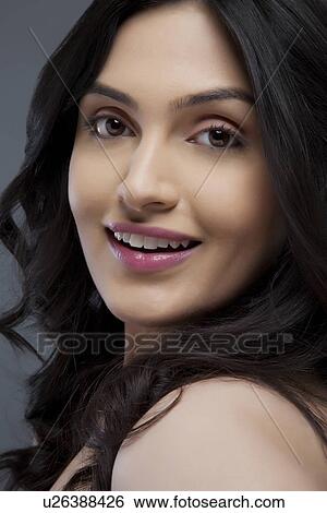 Portrait of an attractive young female smiling over colored background View Large Photo Image Stock Photograph - Portrait of an attractive young female smiling over colored background . Fotosearch