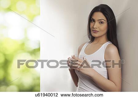 Portrait of an attractive young woman holding tea cup View Large Photo Image Stock Image - Portrait of an attractive young woman holding tea cup . Fotosearch