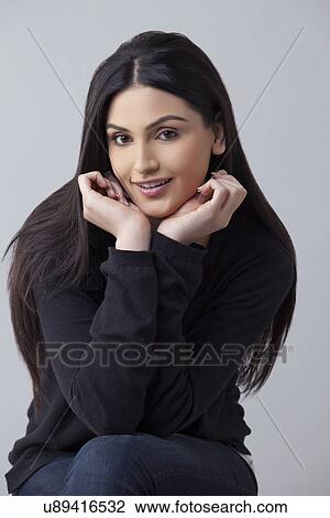 Portrait of an attractive young woman in casual wear smiling over colored background View Large Photo Image Stock Image - Portrait of an attractive young woman in casual wear smiling over colored background . Fotosearch