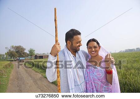 Portrait of an Indian couple smiling with field in background View Large Photo Image Stock Image - Portrait of an Indian couple smiling with field in background . Fotosearch