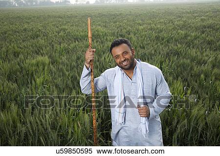 Stock Photography - Portrait of an Indian man holding a stick . Fotosearch