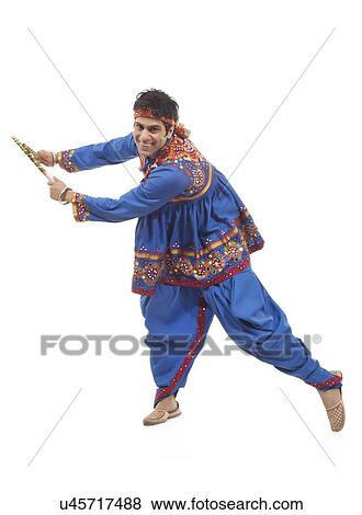 Stock Photo - Portrait of an Indian man performing Dandiya Raas over white background. Fotosearch