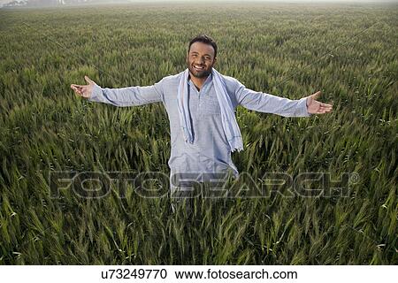 Portrait of an Indian man standing with arms out in a field View Large Photo Image Stock Image - Portrait of an Indian man standing with arms out in a field . Fotosearch