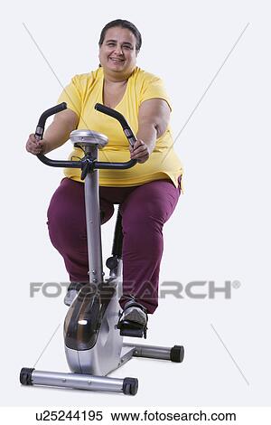 Stock Photography - Portrait of an overweight woman exercising over white background . Fotosearch