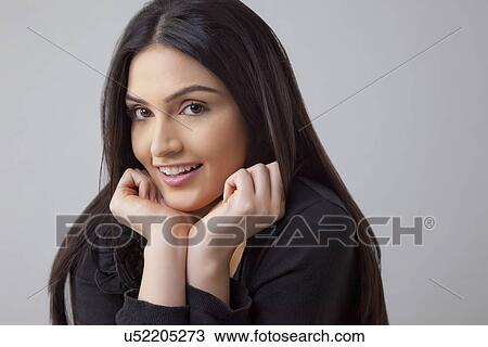 Portrait of beautiful Indian woman smiling over colored background View Large Photo Image Stock Image - Portrait of beautiful Indian woman smiling over colored background . Fotosearch