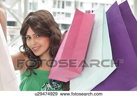 Portrait of beautiful woman showing her shopping bags View Large Photo Image Stock Photo - Portrait of beautiful woman showing her shopping bags . Fotosearch