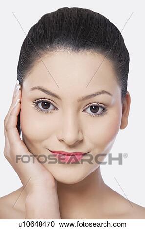 Stock Image - Portrait of beautiful woman with hand on cheek . Fotosearch