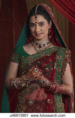Stock Image - Portrait of beautiful young bride in traditional outfit . Fotosearch