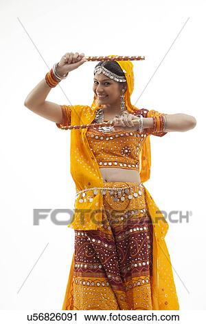 Portrait of beautiful young woman performing Dandiya Raas against white background View Large Photo Image Stock Image - Portrait of beautiful young woman performing Dandiya Raas against white background. Fotosearch