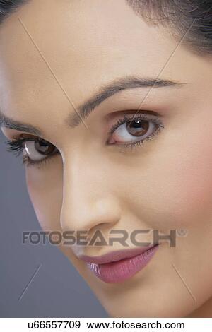 Portrait of beautiful young woman smiling over colored background View Large Photo Image Stock Photo - Portrait of beautiful young woman smiling over colored background . Fotosearch