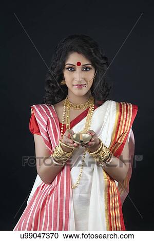 Stock Image - Portrait of Bengali woman holding a diya. Fotosearch