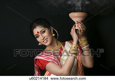 Picture - Portrait of Bengali woman holding a dhunuchi. Fotosearch