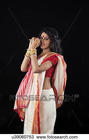 Stock Image - Portrait of Bengali woman holding a conch shell. Fotosearch