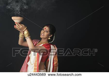 Stock Photo - Portrait of Bengali woman holding a dhunuchi. Fotosearch