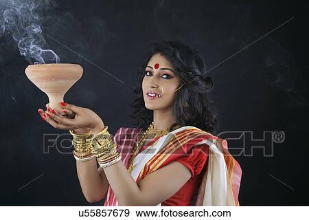 Stock Photo - Portrait of Bengali woman holding a dhunuchi. Fotosearch