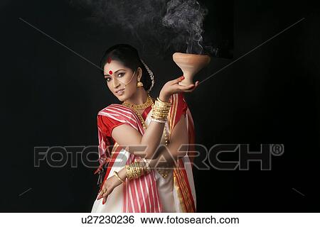 Portrait of Bengali woman holding a dhunuchi View Large Photo Image Stock Photograph - Portrait of Bengali woman holding a dhunuchi. Fotosearch