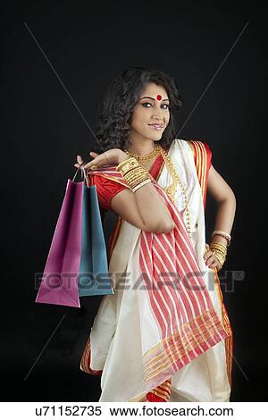 Stock Photography - Portrait of bengali woman holding shopping bags. Fotosearch