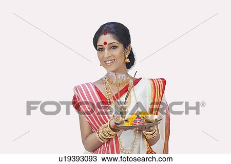 Stock Image - Portrait of Bengali woman with puja thali. Fotosearch
