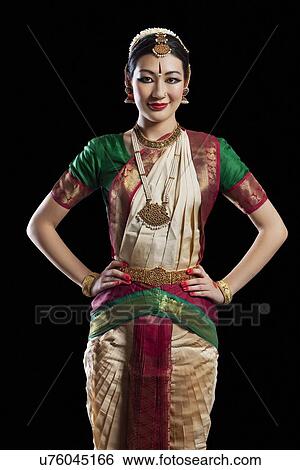 Portrait of Bharatanatyam dancer standing with hands on hips over white background View Large Photo Image Stock Photograph - Portrait of Bharatanatyam dancer standing with hands on hips over white background. Fotosearch