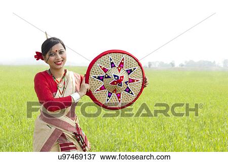 Stock Photo - Portrait of Bihu woman holding a jaapi . Fotosearch