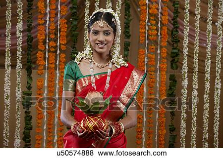 Portrait of bride holding kalash View Large Photo Image Stock Photo - Portrait of bride holding kalash . Fotosearch