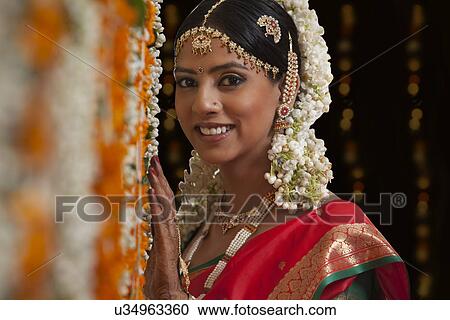 Stock Image - Portrait of bride standing by garlands . Fotosearch